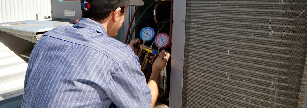 HVAC technician servicing a condenser unit in Glen Allen